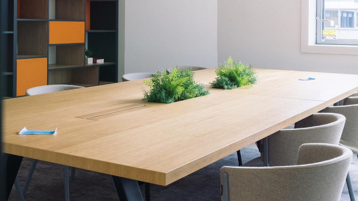 Espace végétalisé dans une salle de réunion avec des petites jardinières encastrées au centre de la table